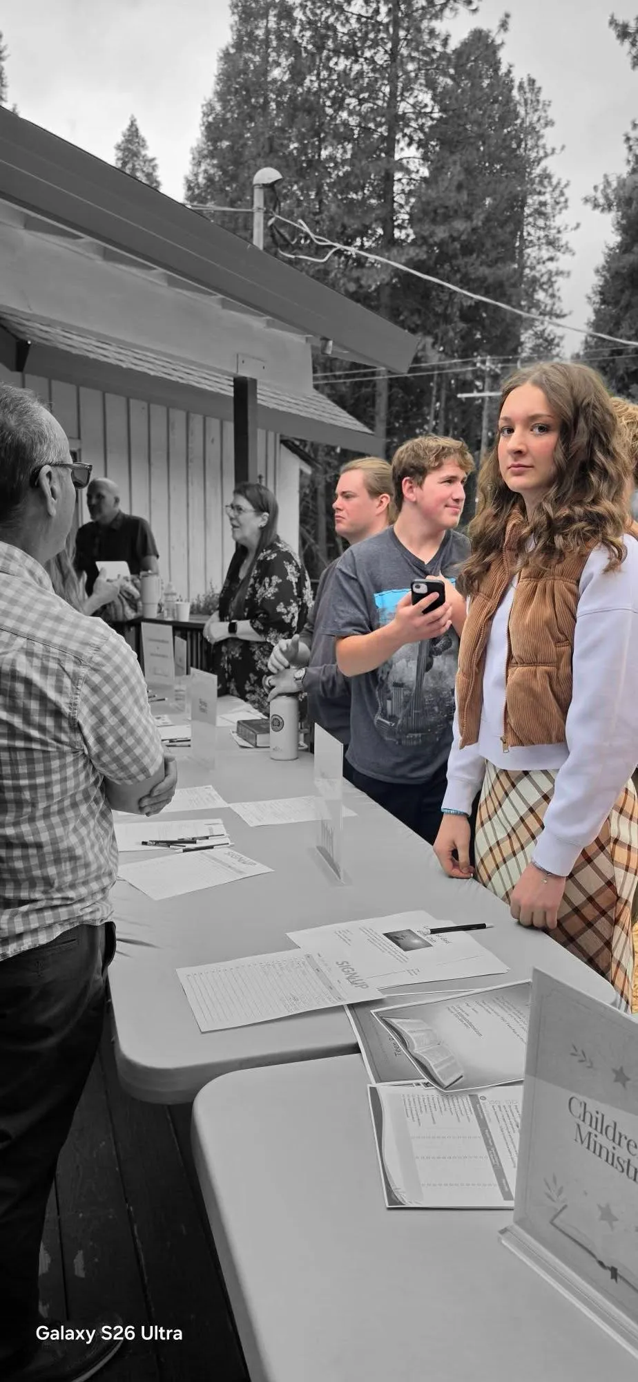 Students at a sign-in table, in black and white